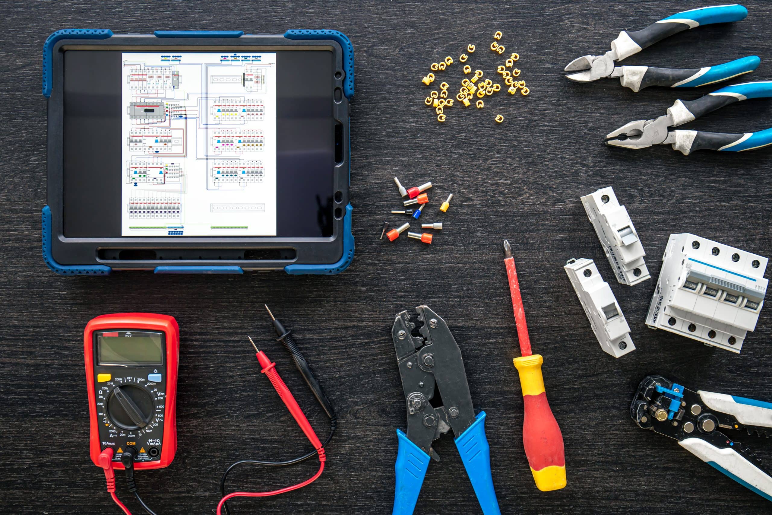 different electrical tools and digital tablet on wooden background, flat lay.